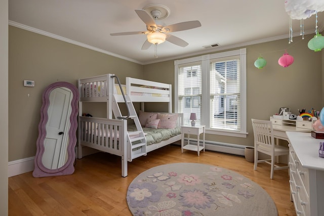 bedroom with a baseboard radiator, multiple windows, light wood-style floors, crown molding, and baseboards