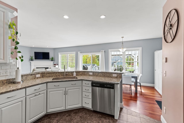 kitchen featuring dishwasher, a sink, plenty of natural light, a peninsula, and recessed lighting