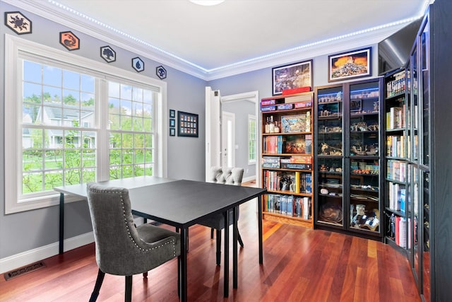 dining space featuring plenty of natural light, crown molding, wood finished floors, baseboards, and an office area