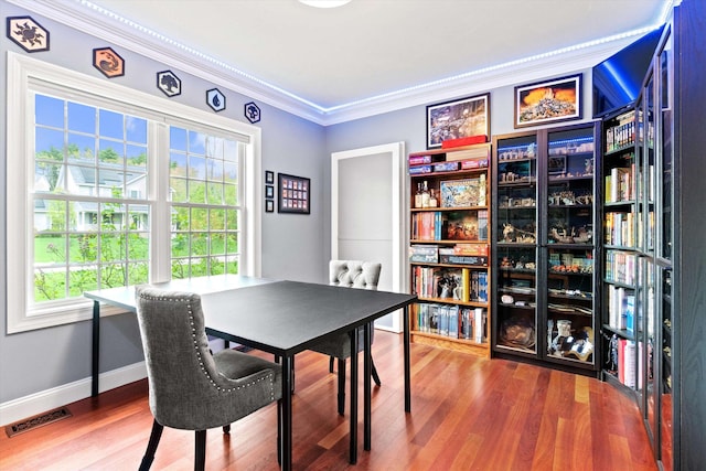 dining space with crown molding, plenty of natural light, wood finished floors, baseboards, and a desk