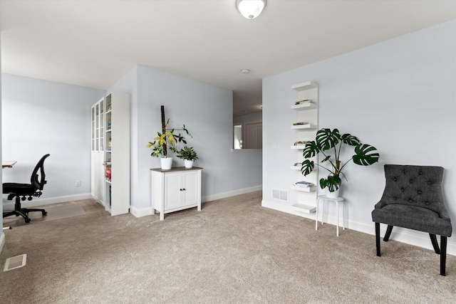 sitting room featuring carpet flooring, a desk, and baseboards