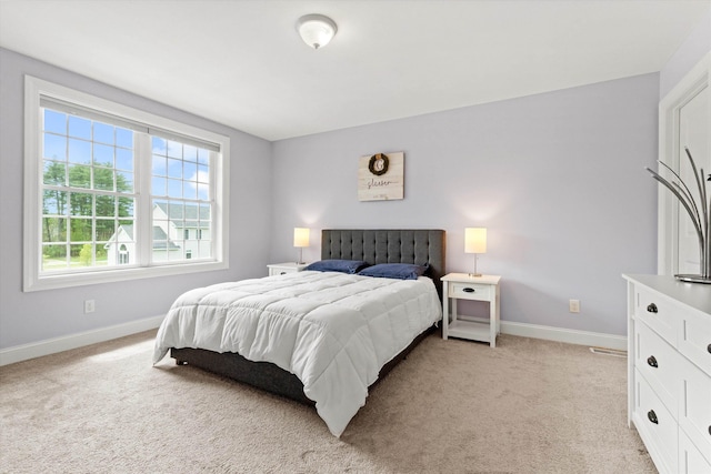 bedroom featuring baseboards and light carpet