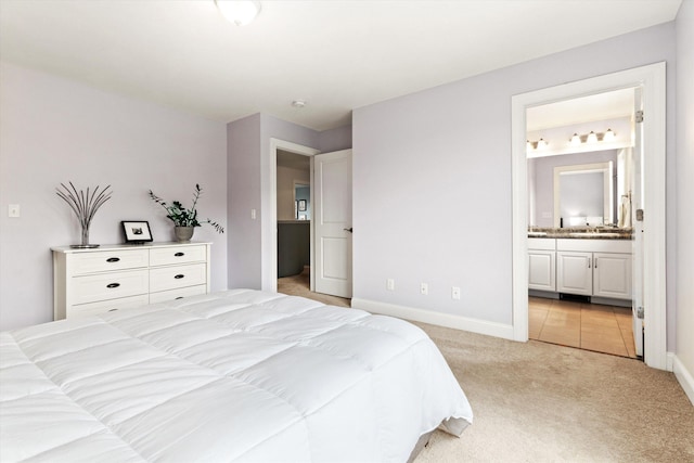 bedroom featuring light carpet, baseboards, and connected bathroom