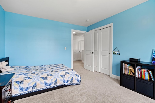 carpeted bedroom with a closet and baseboards