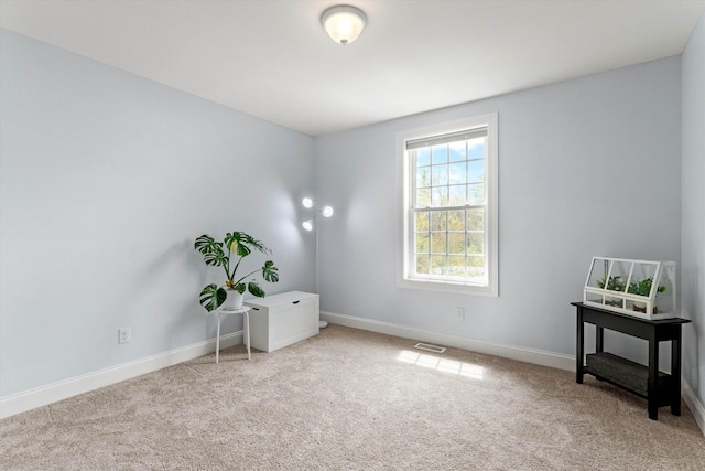 carpeted spare room featuring baseboards