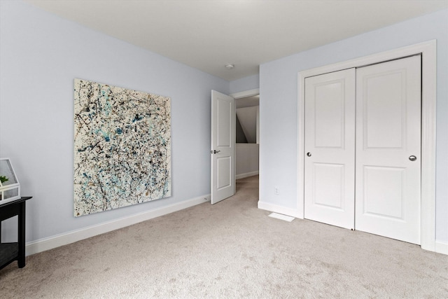 unfurnished bedroom featuring carpet floors, baseboards, and a closet