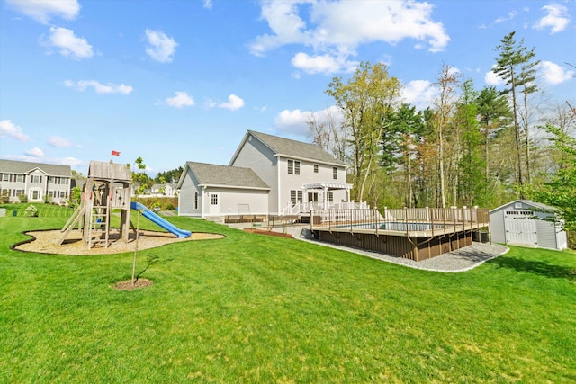 view of grassy yard with a storage unit, an outdoor structure, a playground, a deck, and a pergola