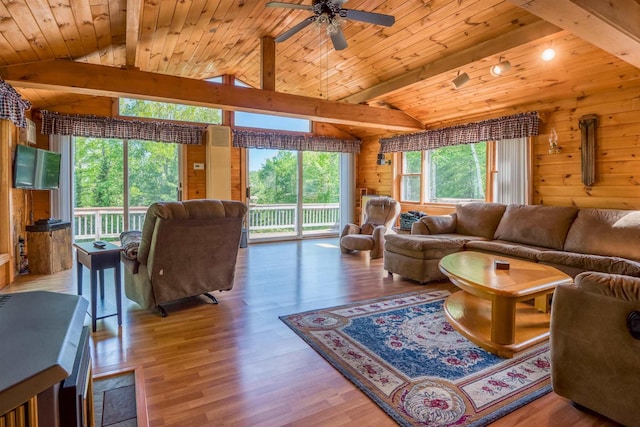 living room featuring wood ceiling, wood finished floors, ceiling fan, and wood walls