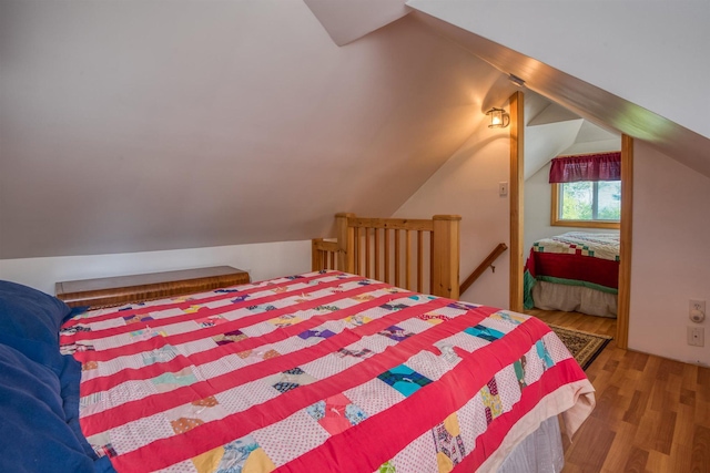bedroom featuring wood finished floors and vaulted ceiling