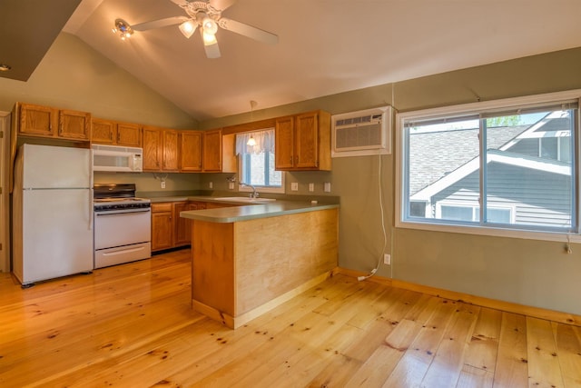 kitchen featuring white appliances, a wall unit AC, a peninsula, a sink, and light wood-style flooring