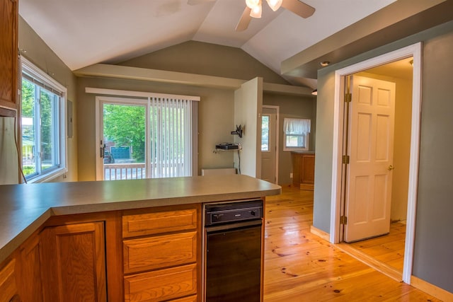 kitchen with brown cabinetry, ceiling fan, lofted ceiling, light wood finished floors, and a peninsula