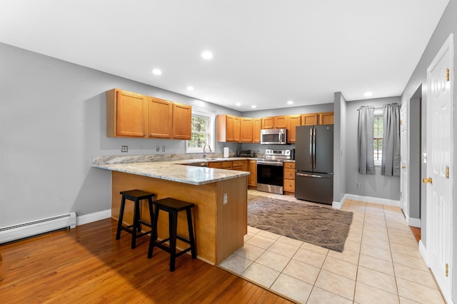 108 Brenner Dr, Conway, NH 03818 - kitchen with stainless steel appliances, a peninsula, light stone counters, recessed lighting, and baseboards