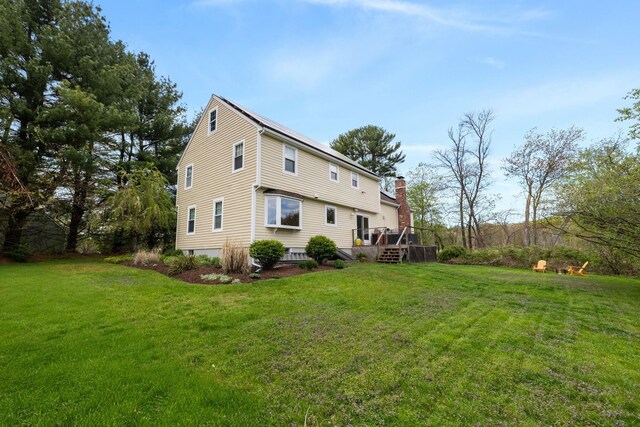 191 Barker St, North Andover, MA 01845 - back of property featuring a deck, a lawn, and a chimney