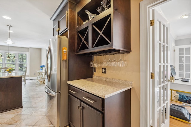 indoor dry bar featuring freestanding refrigerator, decorative light fixtures, recessed lighting, light tile patterned floors, and ornamental molding
