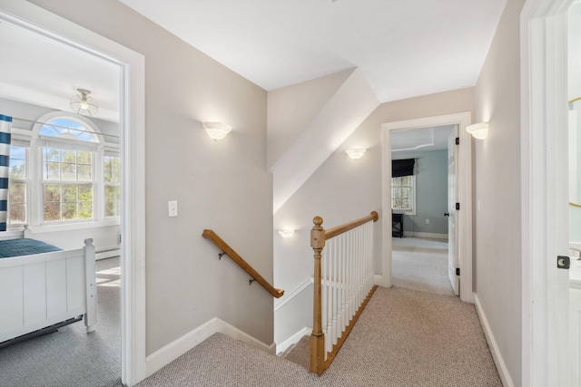 staircase featuring carpet floors, baseboards, and a baseboard heating unit