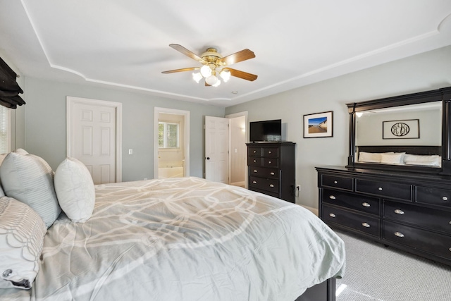bedroom with ensuite bath, carpet, and a ceiling fan