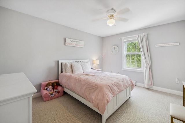bedroom with light colored carpet, baseboards, and a ceiling fan