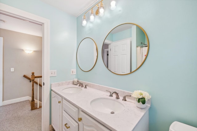 bathroom featuring double vanity, toilet, and baseboards