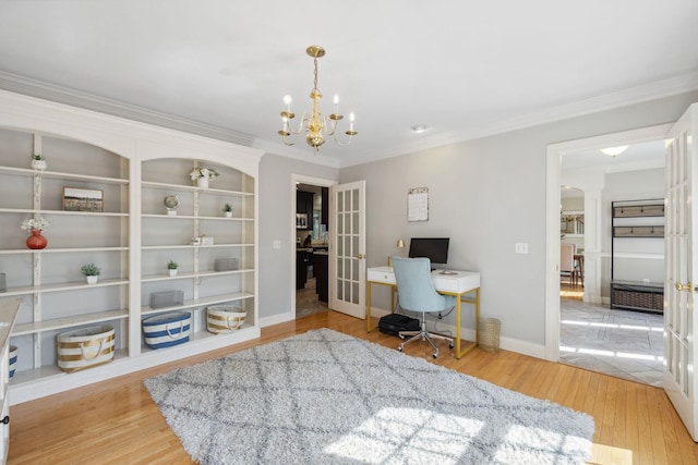 office space with ornamental molding, wood finished floors, a chandelier, decorative columns, and baseboards