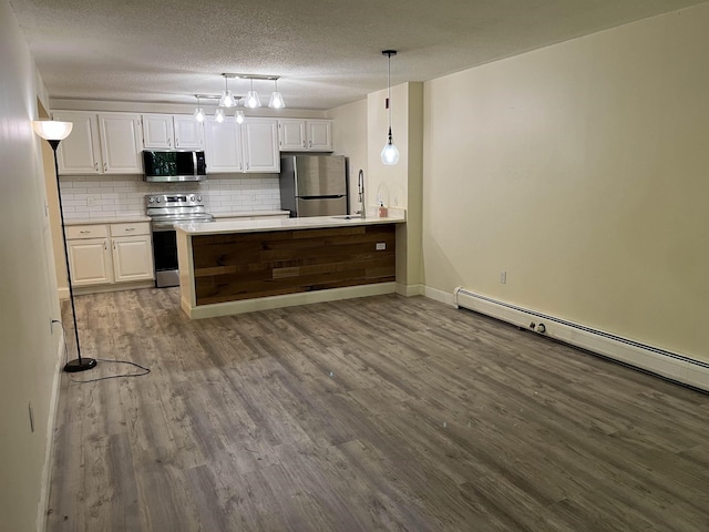 kitchen with appliances with stainless steel finishes, white cabinetry, tasteful backsplash, dark wood-style floors, and baseboard heating