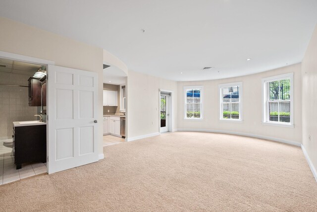 40 College St Unit 210, Burlington, VT 05401 - unfurnished living room with light colored carpet, a sink, baseboards, recessed lighting, and light tile patterned floors