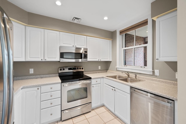 40 College St Unit 210, Burlington, VT 05401 - kitchen with stainless steel appliances, a sink, white cabinetry, light countertops, and light tile patterned flooring