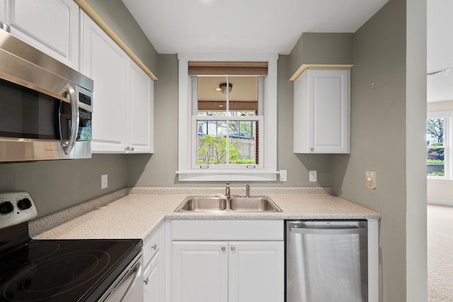 40 College St Unit 210, Burlington, VT 05401 - kitchen featuring stainless steel appliances, a sink, healthy amount of natural light, and white cabinetry