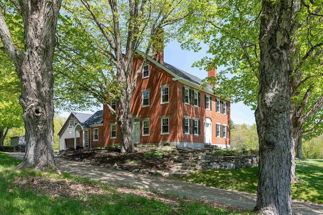 view of home's exterior featuring a chimney and a garage