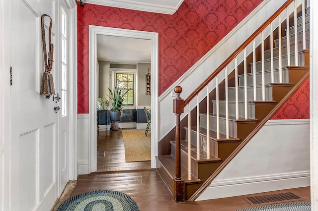stairs featuring wallpapered walls, wainscoting, hardwood / wood-style flooring, and ornamental molding