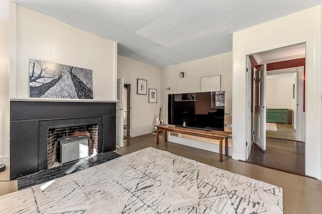 living area with a fireplace with flush hearth and wood finished floors