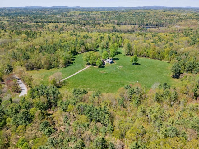 aerial view of property and surrounding area with a heavily wooded area