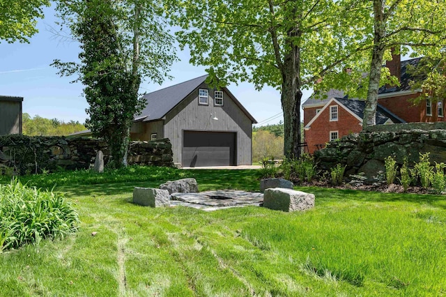 view of yard with a detached garage and an outbuilding