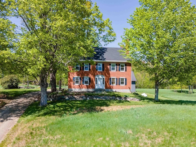 colonial home featuring a front yard
