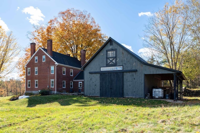 view of property exterior with a barn, a yard, an outdoor structure, a detached garage, and a chimney