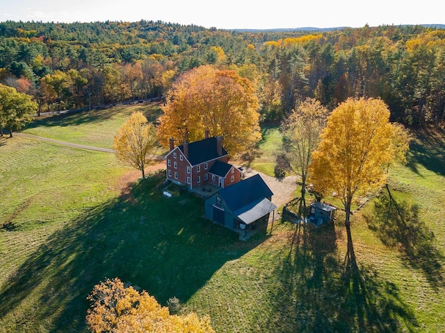 aerial view of property and surrounding area with a heavily wooded area