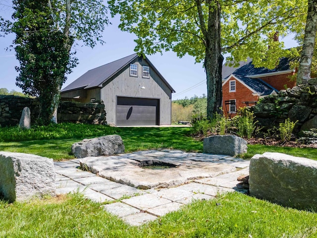 view of green lawn featuring a detached garage and an outdoor structure