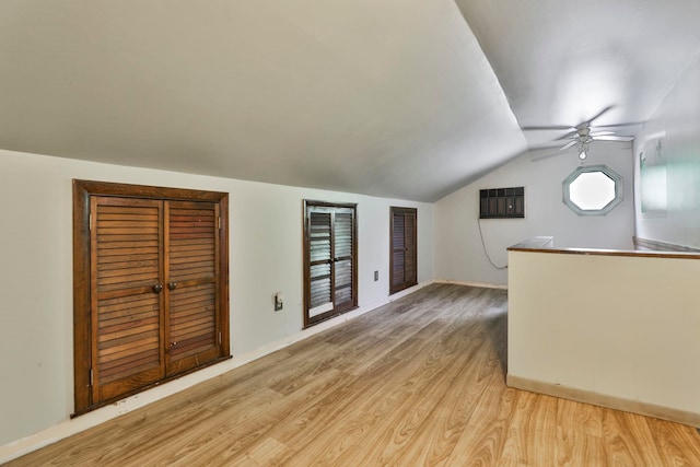 additional living space featuring lofted ceiling, light wood-style floors, a ceiling fan, and baseboards