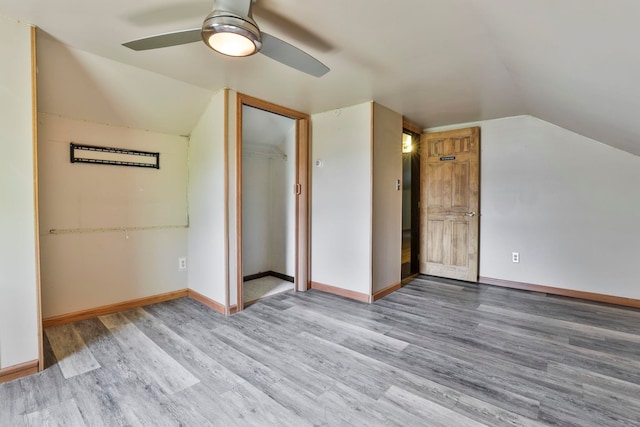 additional living space featuring vaulted ceiling, ceiling fan, light wood-type flooring, and baseboards