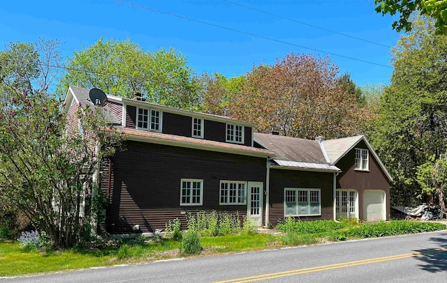 view of front facade with a garage and a chimney