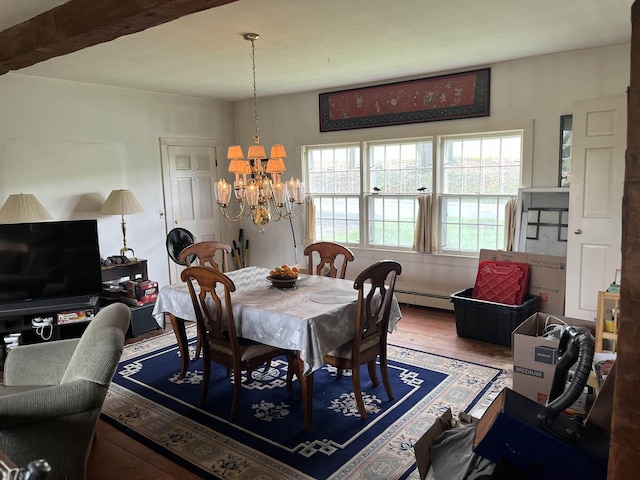 dining area with a baseboard radiator, a chandelier, and wood finished floors
