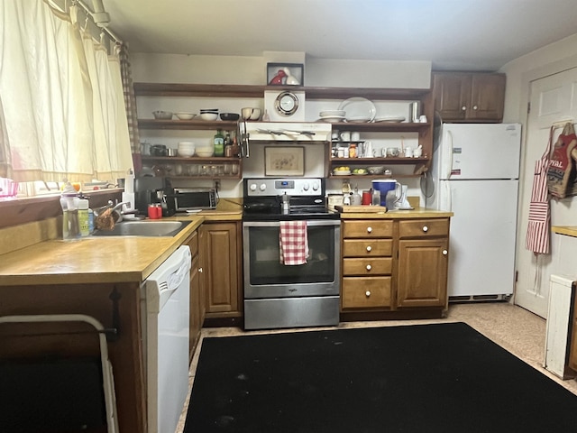 kitchen with white appliances, open shelves, a sink, light countertops, and brown cabinetry