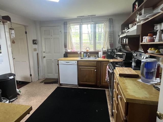 kitchen with dishwasher, a sink, stainless steel range with electric stovetop, light countertops, and open shelves