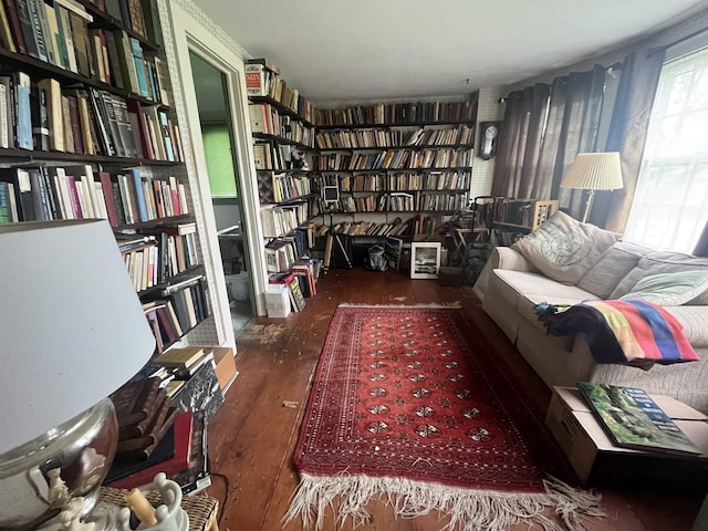 living area with bookshelves and wood finished floors
