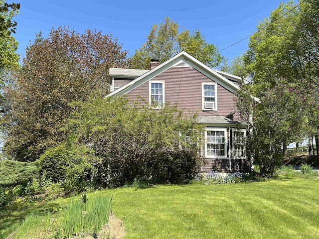 view of home's exterior featuring a chimney and a lawn