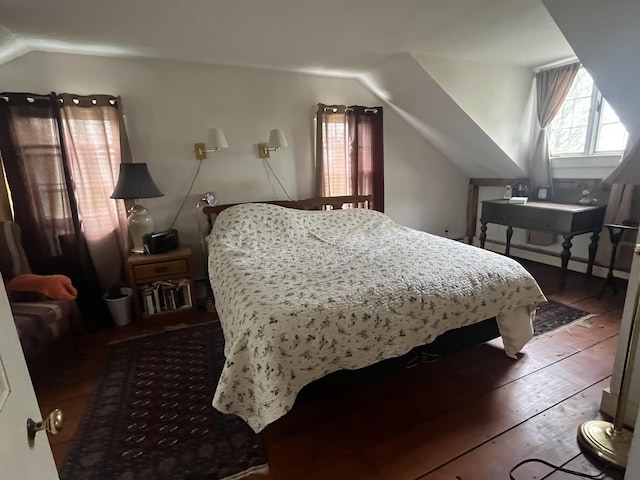 bedroom featuring vaulted ceiling, a baseboard radiator, and hardwood / wood-style floors