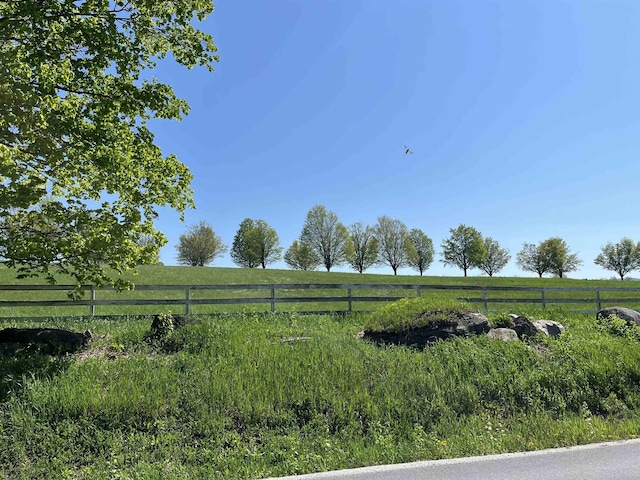 view of yard featuring fence and a rural view