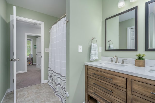 full bath featuring baseboards and vanity