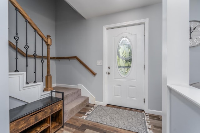 entrance foyer with stairway, wood finished floors, and baseboards