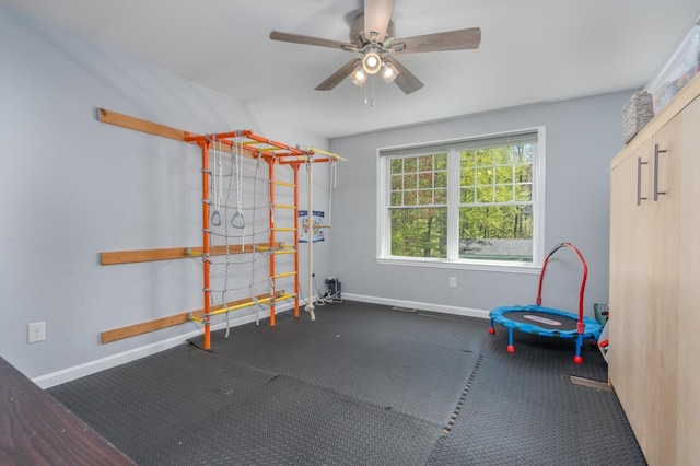 workout area featuring baseboards, ceiling fan, and carpet