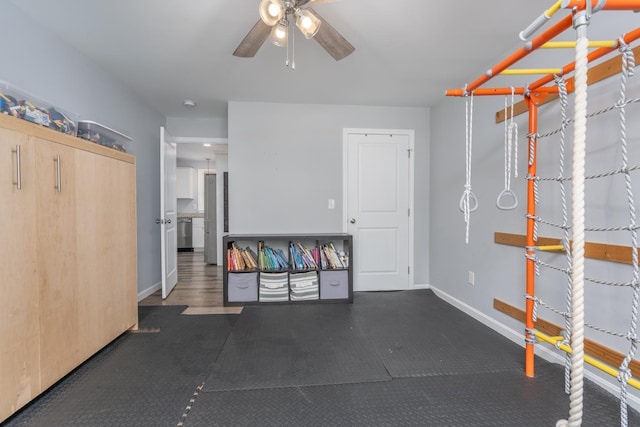 garage with a ceiling fan and baseboards